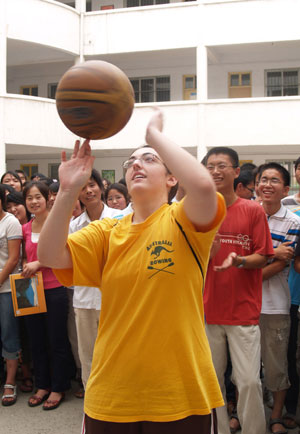 A girl of a 12 members USA President Awardee Students Delegation show her acrobatic skill of finger-rotating basketball, at a local senior high school in Ruyang, central China's Henan Province, July 8, 2008.