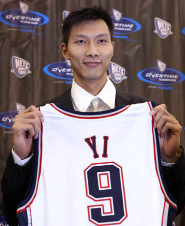 Yi Jianlian of China poses with his New Jersey Nets basketball jersey after a news conference in East Rutherford, New Jersey July 9, 2008. 