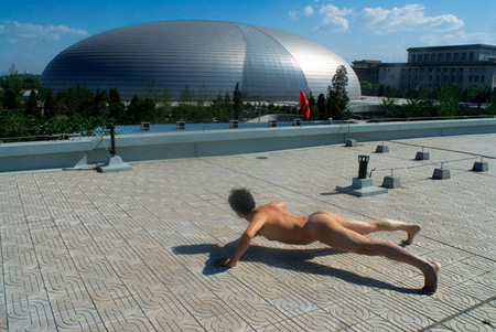 Guangdong TV host Ou Zhihang does pushups near the National Grand Theater in Beijing. He said in his blog: 'I love my country, I also love my body. I contrast my tiny body with the 'miracle of the world' through the popular exercise -- pushup.' (Photo: Ou Zhihang blog)