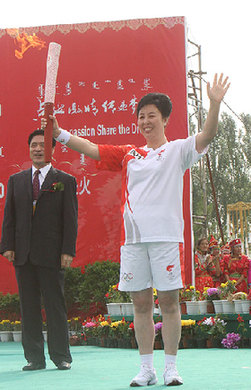 Torchbearer Na Risu displays the Olympic torch in Chifeng, Inner Mongolia Autonomous Region July 10.