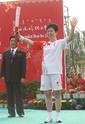 The first torchbearer Na Risu carries the Olympic torch in Chifeng city, Inner Mongolia Autonomous Region, on July 10.