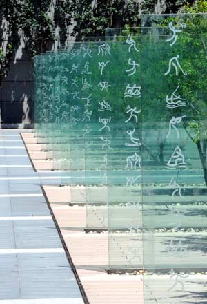 Photo taken on July 6, 2008 shows character symbols of games on glass screen walls at the man-made sinkage square in the Olympic Forest Park in Beijing, capital of China. 