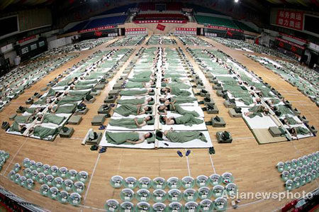 Officials and soldiers responsible for security in the Qinhuangdao division of the Beijing Olympic Games sleep on the floor of the Beijing Olympic Basketball Gymnasium after a whole day patrolling, anti-terrorism drills and military exercises, July 9, 2008. [Asianewsphoto] 