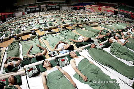 Officials and soldiers responsible for security in the Qinhuangdao division of the Beijing Olympic Games sleep on the floor of the Beijing Olympic Basketball Gymnasium after a whole day patrolling, anti-terrorism drills and military exercises, July 9, 2008. [Asianewsphoto]