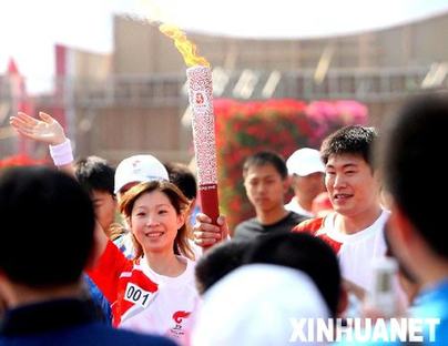 Torchbearers Zhang Dan and Zhang Hao carry the Olympic torch in Harbin, Heilongjiang Province July 11.