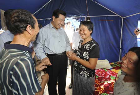 Jia Qinglin (3rd R), chairman of the National Committee of the Chinese People's Political Consultative Conference (CPPCC), hold the hands of quake victims in a makeshift tent during his visit to the quake-hit Guangping Township, Ningqiang County, northwest China's Shaanxi Province, July 6, 2008. 