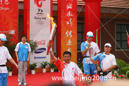 The first torchbearer Hu Zhiqiang runs with the Olympic torch in Daqing, Heilongjiang province, on July 12, 2008.
