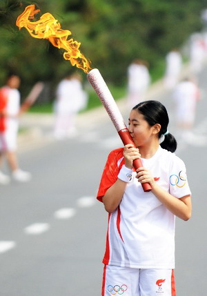 Photo: Torchbearer kisses the torch
