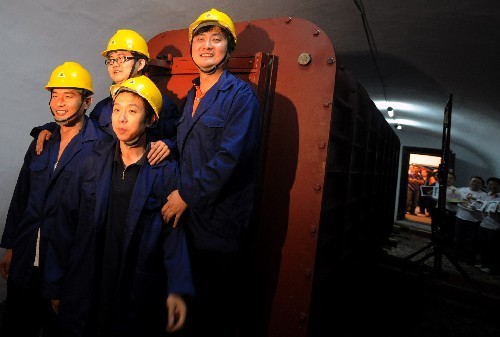 Staff workers celebrate a successful simulation in the capsule. [Photo: Xinhua]