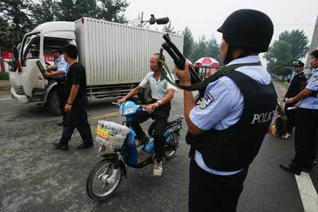 Armed police officers carry out safety inspections of vehicles at a check point in Beijing on July 14, 2008. [Photo: cnsphoto] 
