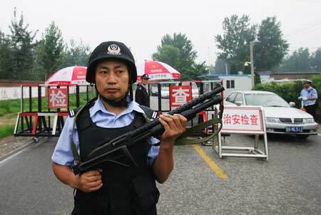 Armed police officers carry out safety inspections of vehicles at a check point in Beijing on July 14, 2008. [Photo: cnsphoto] 