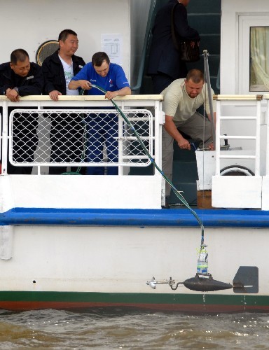 The picture taken on June 5 shows that Chinese and Russian environmental workers collect water samples on the Heilongjiang River during a joint observation and survey of the river.