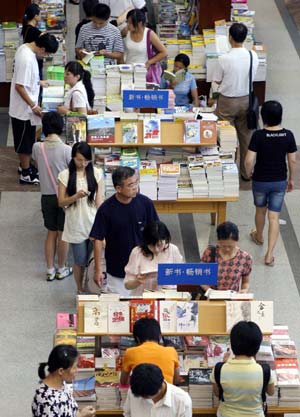 People read books in a bookstore in Shanghai, east China, July 15, 2007. An increasing number of people in Shanghai choose to stay in the the air conditioned bookstores to read books during the summer time. 