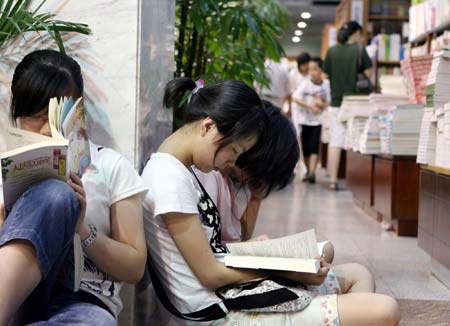 People read books in a bookstore in Shanghai, east China, July 15, 2007. An increasing number of people in Shanghai choose to stay in the the air conditioned bookstores to read books during the summer time. 