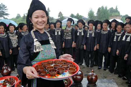 Women of Shui ethnic group offer guests with wine as they celebrate the Mao Festival in Shui Autonomous County of Sandu, southwest China's Guizhou province, July 14, 2008. The Mao Festival of Shui ethnic group, an occasion to pray for benign climate and a good harvest, kicked off there on Monday.