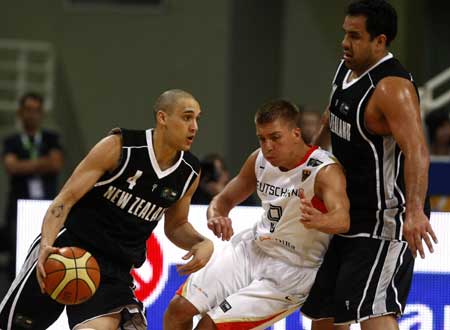 New Zealand's Lindsay Tait (L) drives the ball against Germany's Steffen Hamann (C) as Pero Cameron looks on during their basketball game at FIBA Olympic qualifying tournament in Athens July 16, 2008.