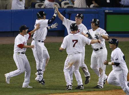 Minnesota Twins Justin Morneau (C) celebrates with American League teammate J.D. Drew (7) after scoring in the 15th inning on a bases-loaded sacrifice fly by Texas Rangers Michael Young as they defeated the National League in Major League Baseball's All-Star game at Yankee Stadium in New York July 15, 2008. 