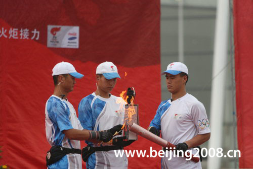 The picture shows that the flame escorts light the lantern at the ceremony during the torch relay in Shenyang, Liaoning Province, on July 17, 2008.
