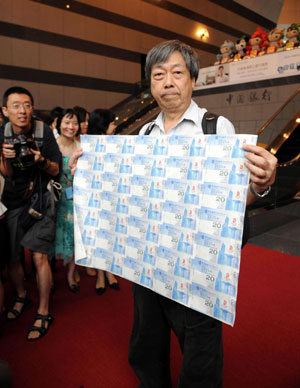 A Hong Kong resident shows his special edition HK$20 Olympic banknotes at Bank of China in Central, Hong Kong, July 16, 2008.Four million banknotes have been officially issued in Hong Kong, Macao and some overseas regions. There are three categories of banknotes: a single bill, a set of four and a set of 35. 