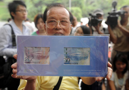 A Hong Kong resident shows his special-edition HK$20 Olympic banknotes at Bank of China in Central, Hong Kong, July 16, 2008. Four million banknotes have been officially issued in Hong Kong, Macao and some overseas regions. There are three categories of banknotes: a single bill, a set of four and a set of 35.