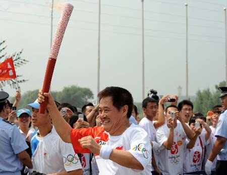 Torchbearer Zhao Benshan, a famous comedian runs during the 2008 Beijing Olympic Games torch relay in Shenyang, capital of northeast China's Liaoning Province, on July 17, 2008. 