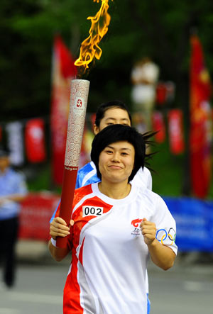 Torchbearer Hua Ju, a former weightlifting player runs during the 2008 Beijing Olympic Games torch relay in Anshan, city of northeast China's Liaoning Province, on July 18, 2008.