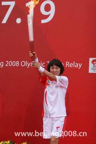 Wang Junxia displays the Olympic torch at the launching ceremony of the Dalian leg of relay on Saturday.