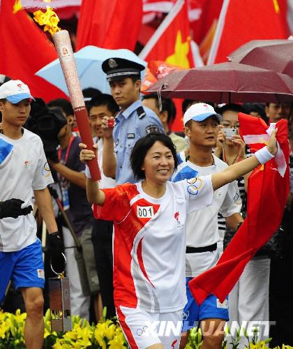 Chinese former athletics Olympics champion Wang Junxia becomes the first torch bearer during the Olympic torch relay in Dalian, northeast China's Liaoning province, on Saturday, July 19, 2008. 