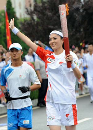 Torchbearer Sun Jiayi runs with the torch during the 2008 Beijing Olympic Games torch relay in Dalian, city of northeast China's Liaoning Province, on July 19, 2008.