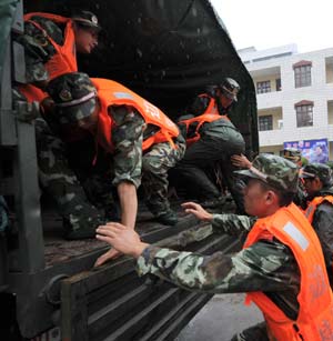 Soldiers and military officers get on a truck to reach the areas vulnerable to typhoon attacks in Fuzhou, capital of east China's Fujian Province, July 18, 2008.