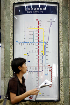 A commuter walks past a Beijing Subway Map at a subway station in Beijing July 17, 2008. 