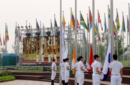 Flag bearers raise flags in the Olympic Village in Beijing on July 20, 2008. The village began testing operations on Sunday and will be officially opened on July 27 for the Olympics and Paralympics. [Xinhua] 