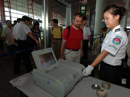 Security staff conducts special security checks at the entrance of terminal 3 of the Beijing Capital International Airport in Beijing, China, on July 20, 2008. (Xinhua Photo)