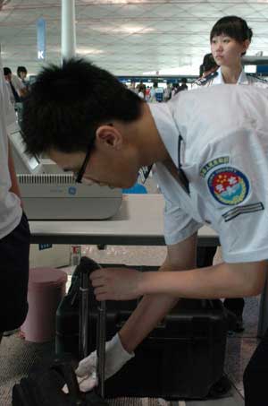 Security staff checks a piece of luggage at the Beijing Capital International Airport in Beijing, China, on July 20, 2008. (Xinhua Photo)