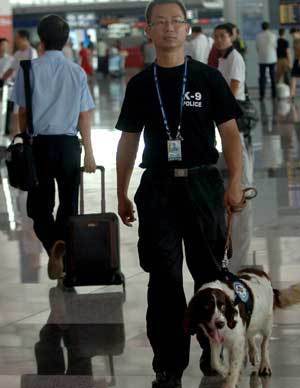 A policeman patrols with a police dog at terminal 3 of the Beijing Capital International Airport in Beijing, China, on July 20, 2008. (Xinhua Photo)