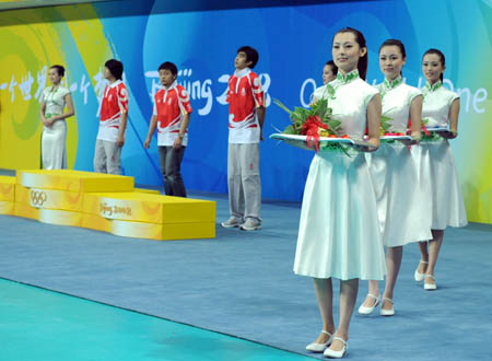 Models display the flow of Olympic awarding ceremonies during a conference to display sport presentations and awarding ceremonies of the 2008 Beijing Olympic Games in the gym of Beijing Institute of Technology in Beijing, on July 20, 2008. (Xinhua Photo)