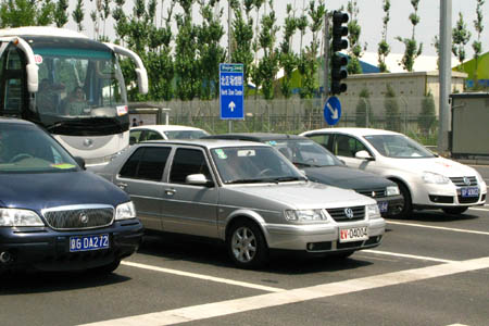 Vehicles stop at the traffic lights on Lincui Road near the Olympic Village in Beijing, on July 20, 2008. The Chinese capital began on Sunday a two-month-long control of vehicle use to ease traffic pressure and improve air quality for the Olympic Games, set to open in 19 days.