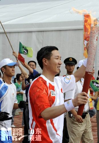 Tochbearer Chen Aixin carries the Olympic torch in Qingdao, Shandong Province July 21.
