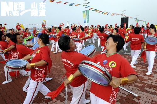 Local people dance to welcome the Olympic torch in Qingdao, Shandong Province July 21.