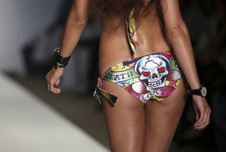 A model walks the runway wearing Ed Hardy swimwear 2009 collection by designer Christian Audigier during Mercedes-Benz Fashion Week Swim show in Miami July 19, 2008.