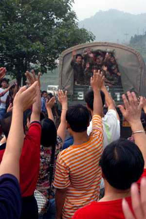 Local residents wave good-bye to soldiers of Chinese People’s Liberation Army (PLA) in Shifang of southwest China’s Sichuan Province on July 20, 2008. The first batch of PLA soldiers withdraw from the quake-hit city of Shifang on Sunday. 