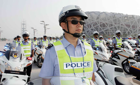 Members of the Beijing Olympic emergency team that deals with traffic situations stand by in front of the National Stadium or 'Bird's Nest', July 20, 2008. The Olympic transportation security drill was held in the Beijing Olympic area on the same day. [Xinhua]