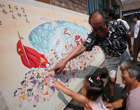 Dong Jing, an artist of traditional Chinese New Year painting, shows a girl his latest piece of work on the theme of welcoming the Beijing 2008 Olympics to local residents in Ninghe county, Tianjin Municipality, July 21 2008. The paining is 1.75 meters long and 0.93 meter high, and takes Dong forty days to finish. [Xinhua]