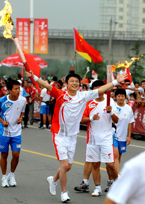 Torchbearer Gao Peng runs with the torch during the 2008 Beijing Olympic Games torch relay in Linyi City, east China&apos;s Shandong Province, on July 21, 2008.