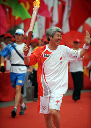 Torchbearer Zhao Zhiquan runs with the torch during the 2008 Beijing Olympic Games torch relay in Linyi City, east China&apos;s Shandong Province, on July 21, 2008.