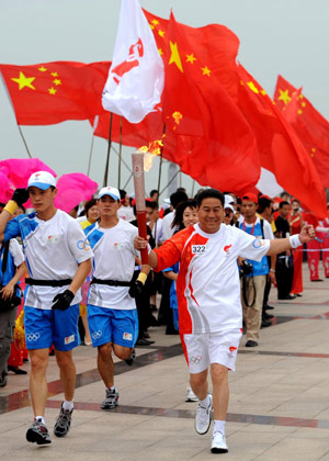 Torchbearer Wang Tingjiang runs with the torch during the 2008 Beijing Olympic Games torch relay in Linyi City, east China&apos;s Shandong Province, on July 21, 2008.