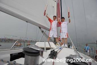 Torchbearers strike a pose on the 'Qingdao' sailboat during the torch relay in Qingdao, Shandong Province, on July 21, 2008.