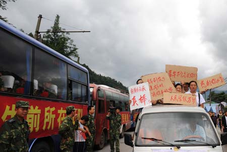 Local villagers hold cardboards to express their thanks to the People's Liberation Army (PLA) soldiers in the quake-hit Yinghua Town in Shifang City of southwest China's Sichuan Province, July 21, 2008.