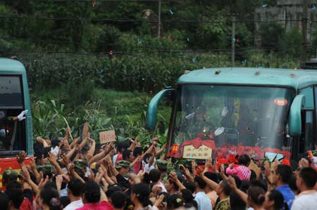 Local villagers express their thanks to the People's Liberation Army (PLA) soldiers as they are leaving the quake-hit Yinghua Town in Shifang City of southwest China's Sichuan Province, July 21, 2008.