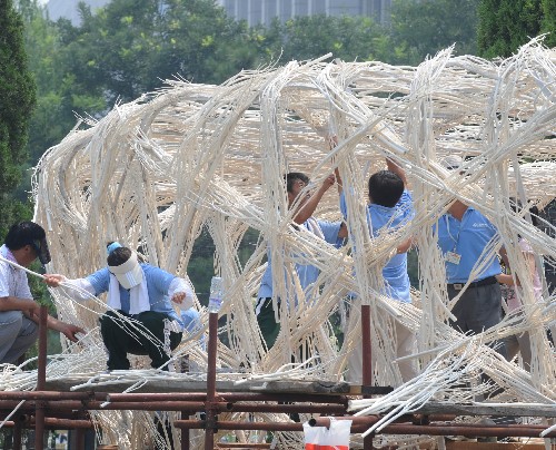 Workers are busy with erecting the structure for a Bird's Nest-shaped flower sculpture at Beijing's Tian'anmen Square on Tuesday, July 22, 2008.